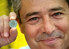 Carlos Iglesias muestra una moneda de un franco suizo
