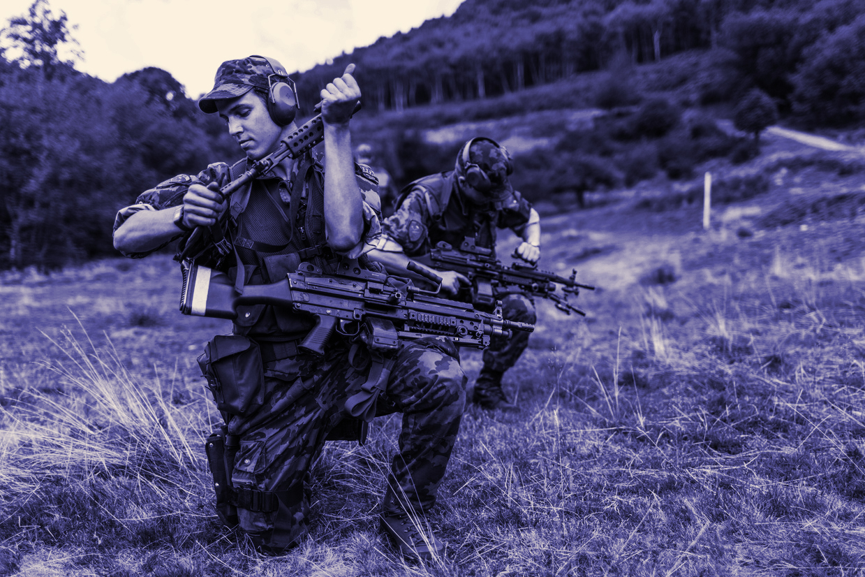 two swiss soldiers in uniform with machine guns.