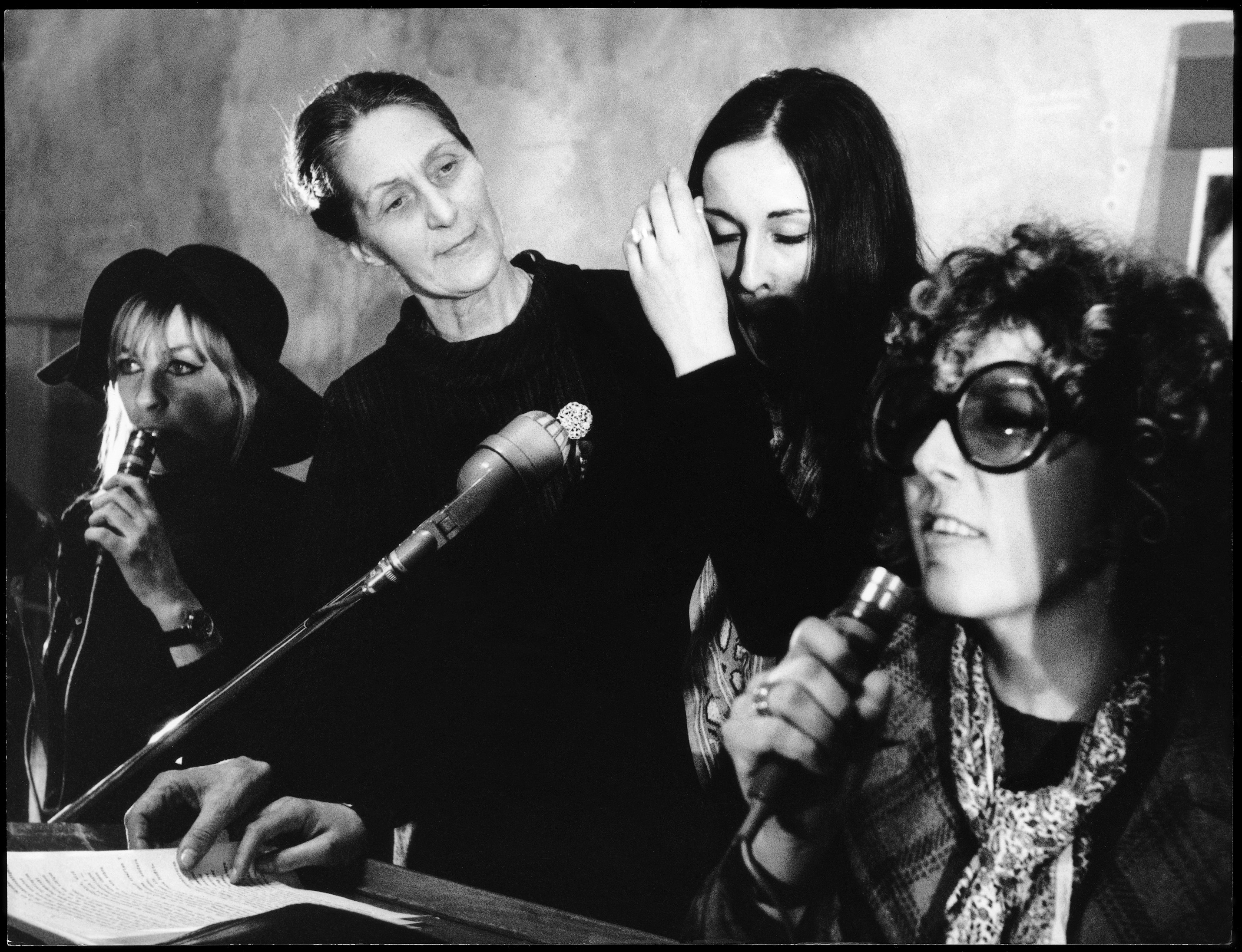 four women in front of microphones