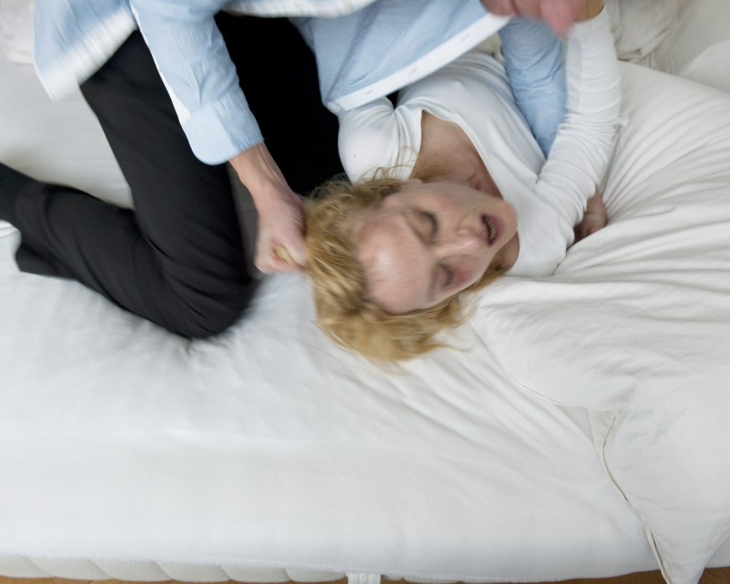 Ein Mann zieht eine Frau am den Haaren (gestellte Szene)