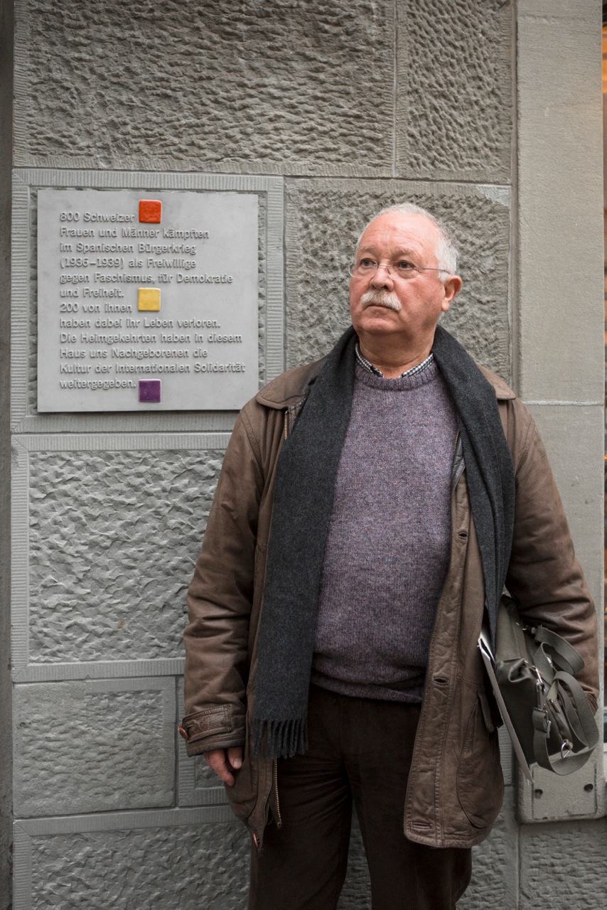 Bruno Kammer junto a la placa conmemorativa d elos 800 voluntarios suizos que lucharon en las Brigadas Internacionales
