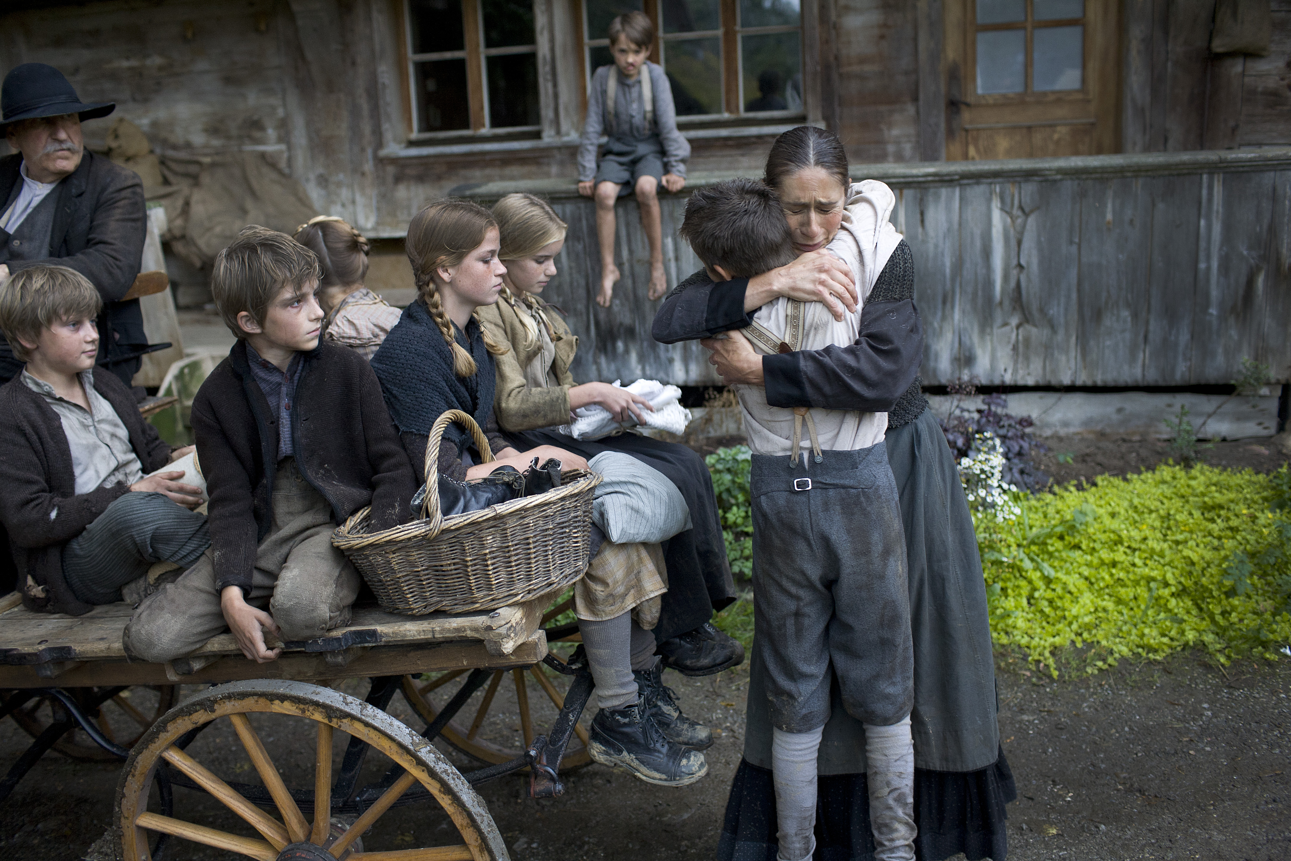 A woman hugs a child with others in a cart