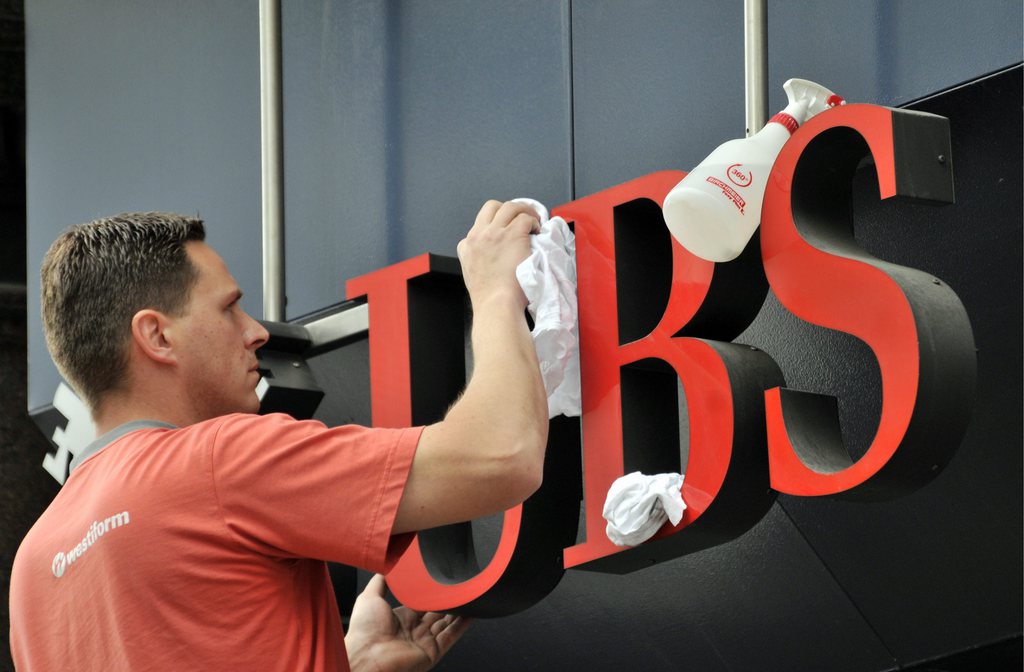 Un hombre limpia el anuncio del UBS