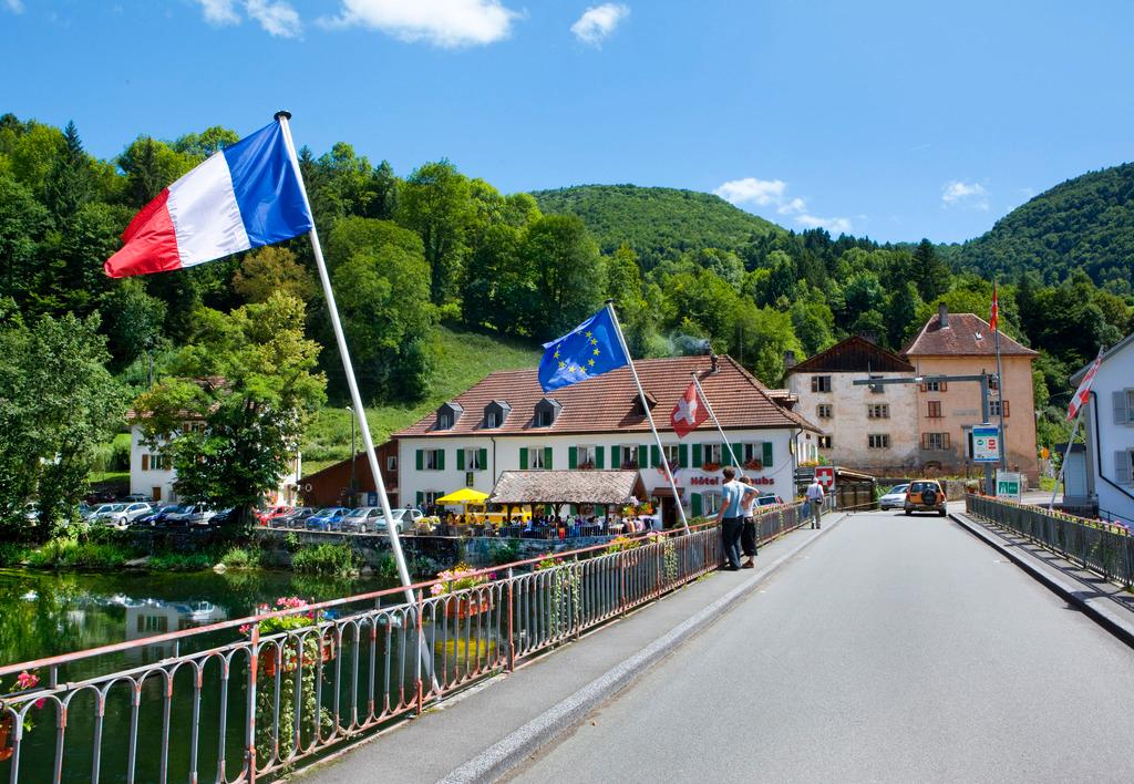 Brücke zwischen Frankreich und der Schweiz im Jura und mit Flaggen der beiden Länder
