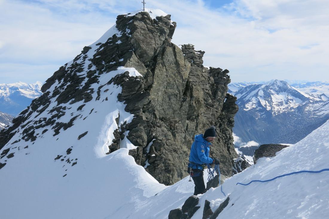 scalatore in cima a una montagna innevata