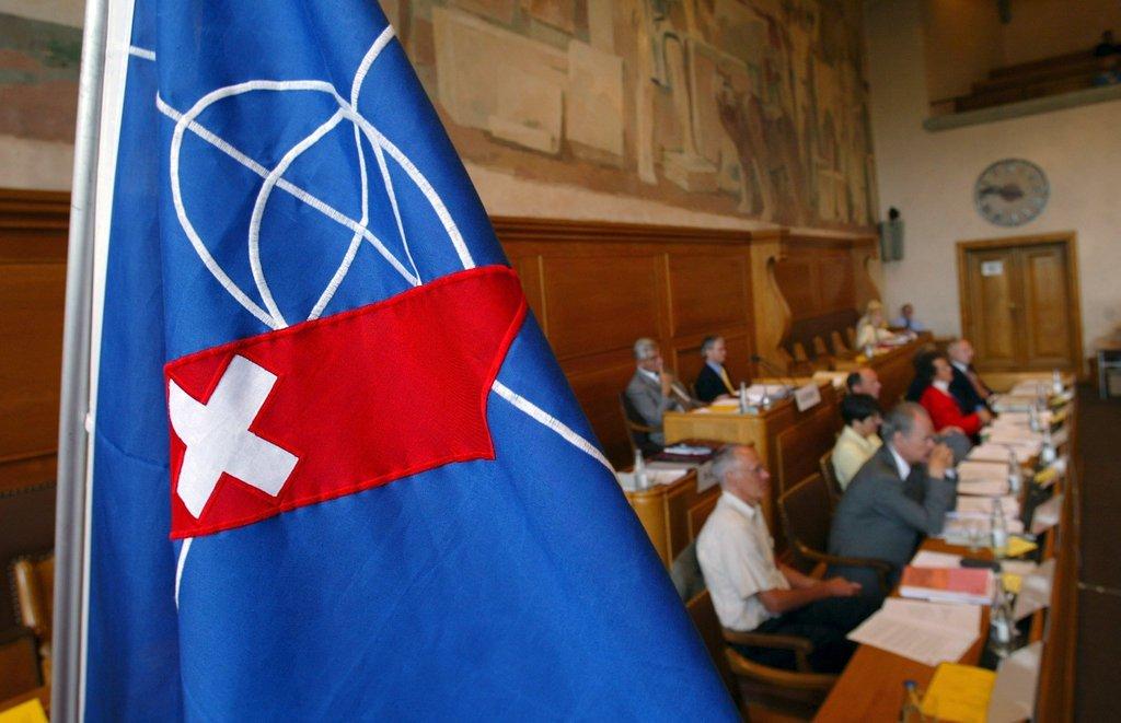 Personas en congreso con bandera de la OSE en primer plano