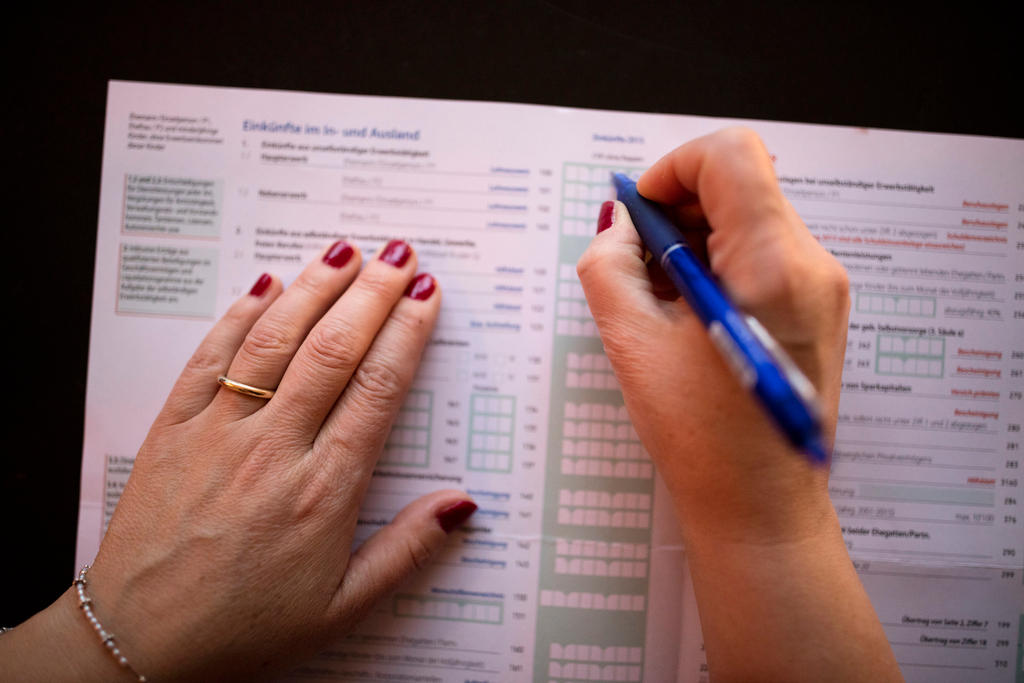 A married woman fills in details as to income made domestically and internationally in a Swiss tax return