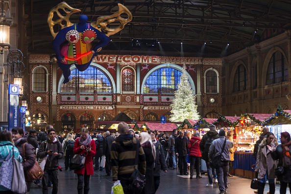 Viele Menschen in der Halle des alten Hauptbahnhofs Zürich mit dem Schutzengel von Nikki de Saint Phalle