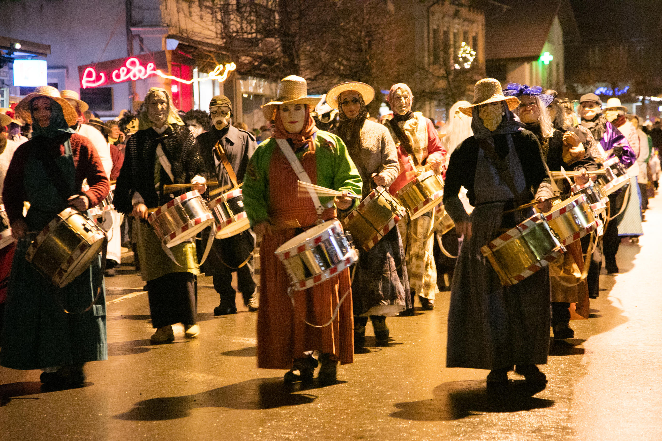 Masked figures banging drums.