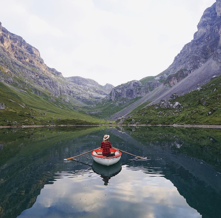 Frau in einem Boot auf einem einsamen Bergsee