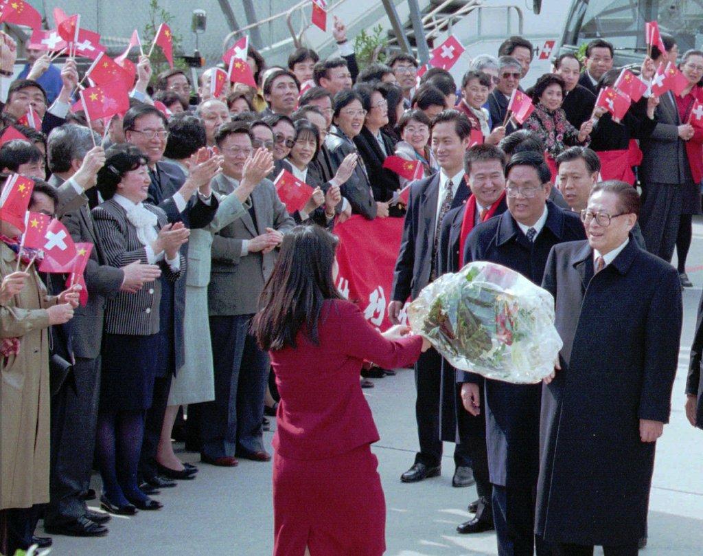在日内瓦机场上,一名年轻女性向中国代表团献花。