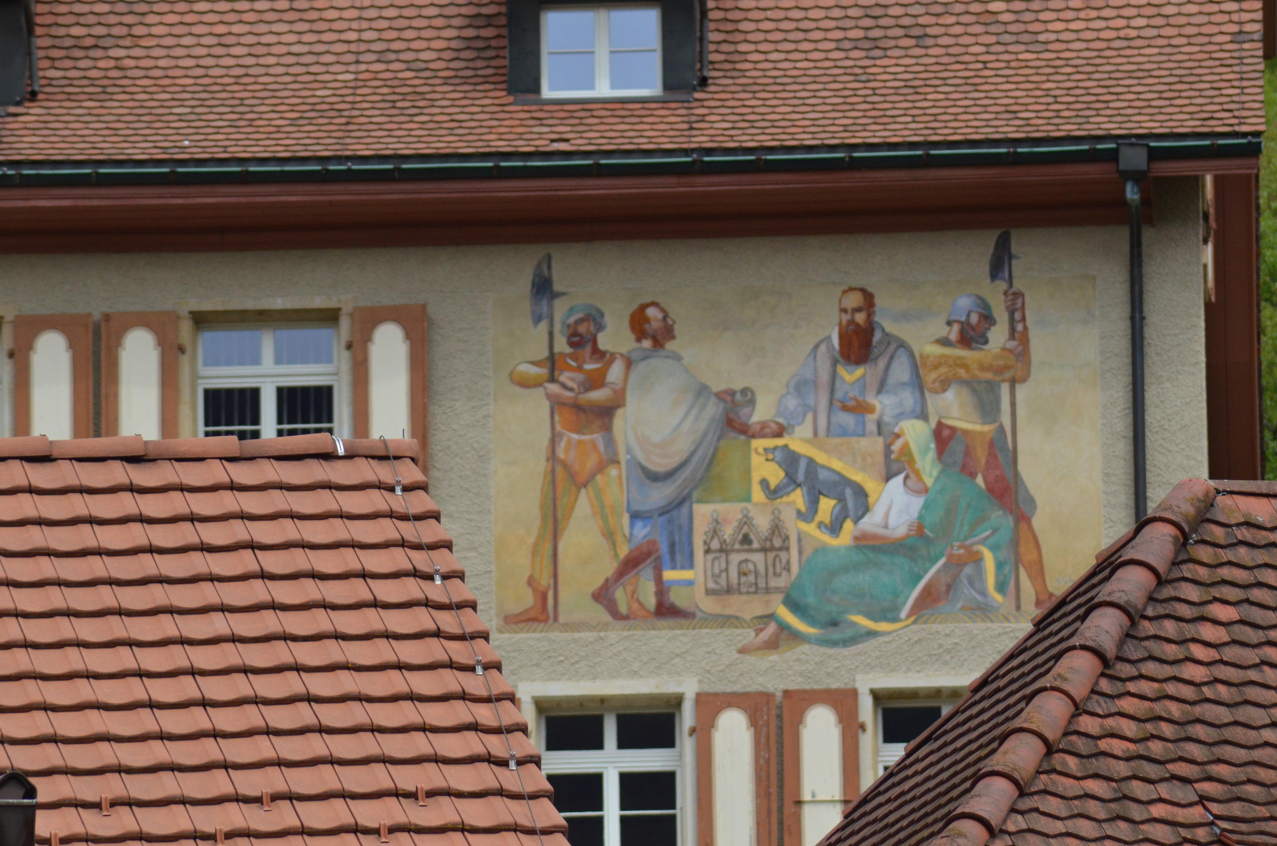 A painting featuring soldiers and the Bernese flag on the side of the castle in Moutier