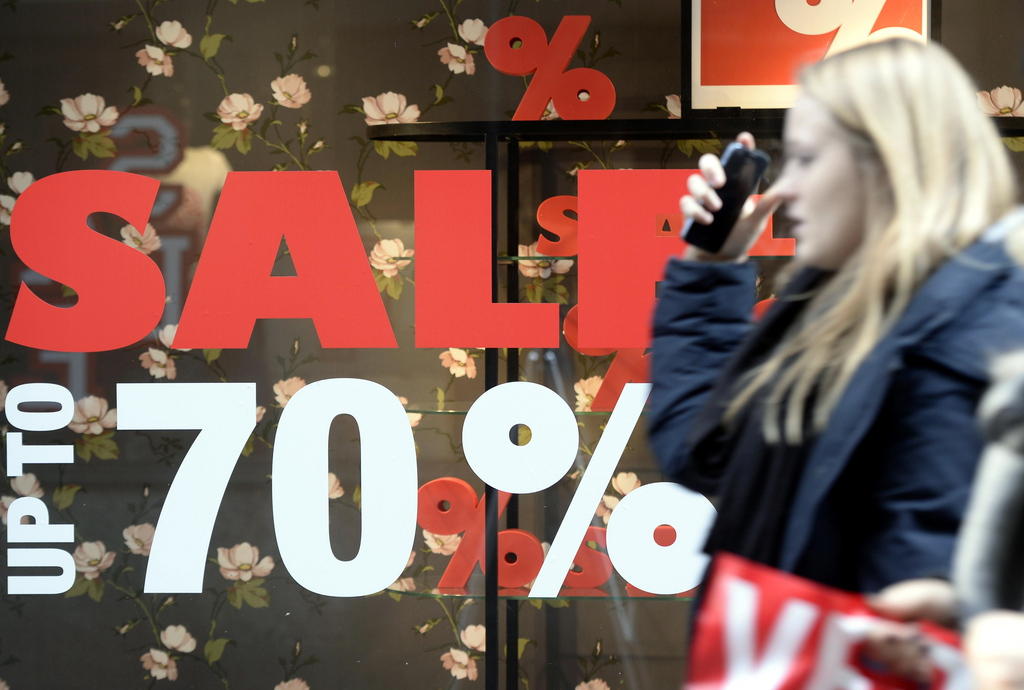 Eine Frau geht an einem Schaufenster vorbei, auf dem Sale 70% steht.
