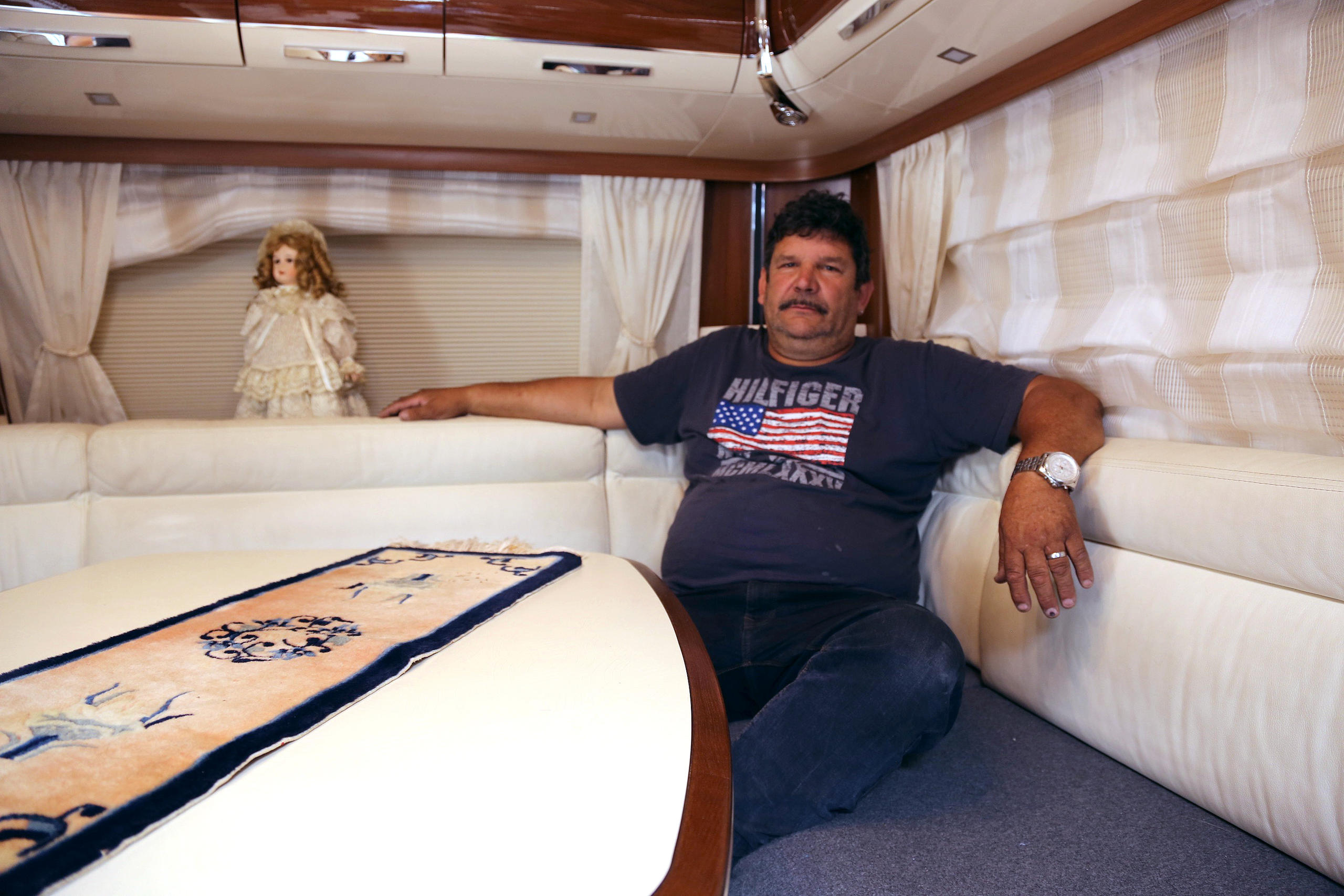 A man sits in a caravan and looks directly at then camera