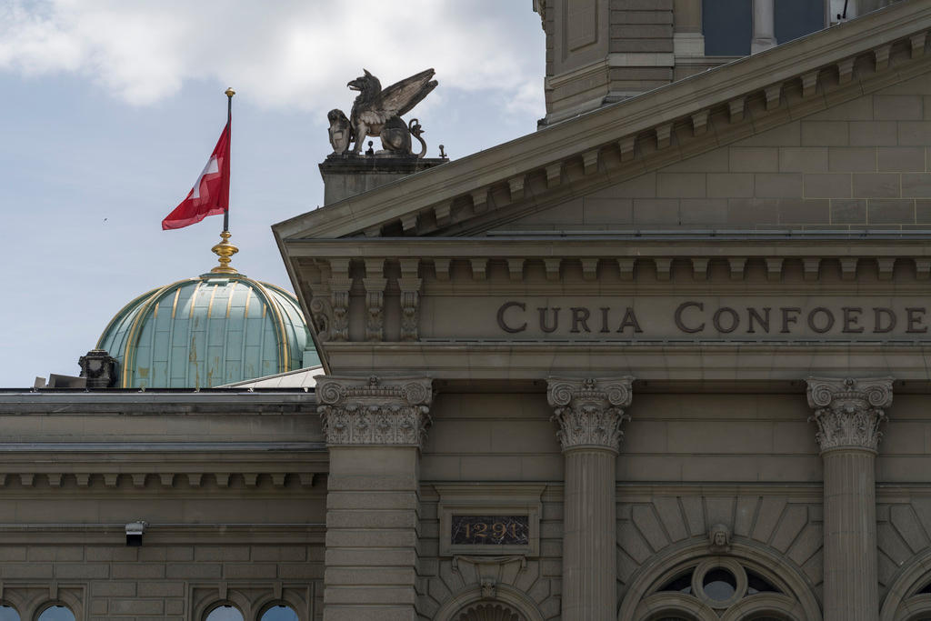 The Swiss flag flies atop the dome of the Swiss parliament building in Bern