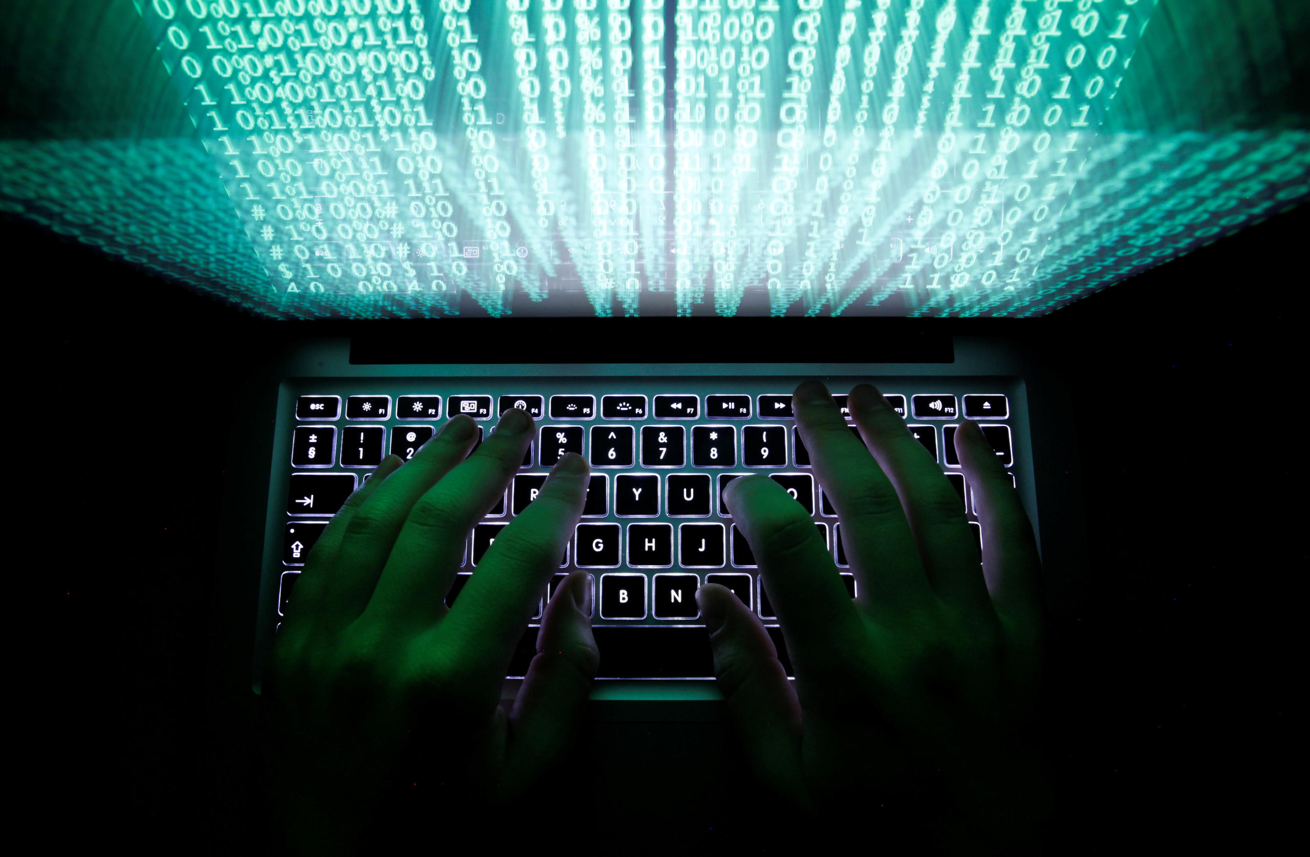 Numbers light up a computer screen as a pair of hands use the keyboard