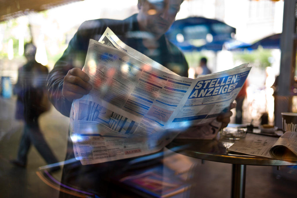 Immagine di un uomo che consulta annunci di posti di lavoro vacanti su un giornale.