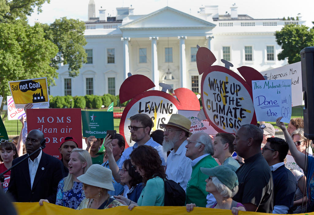 Protesters hold signs outside of the White House
