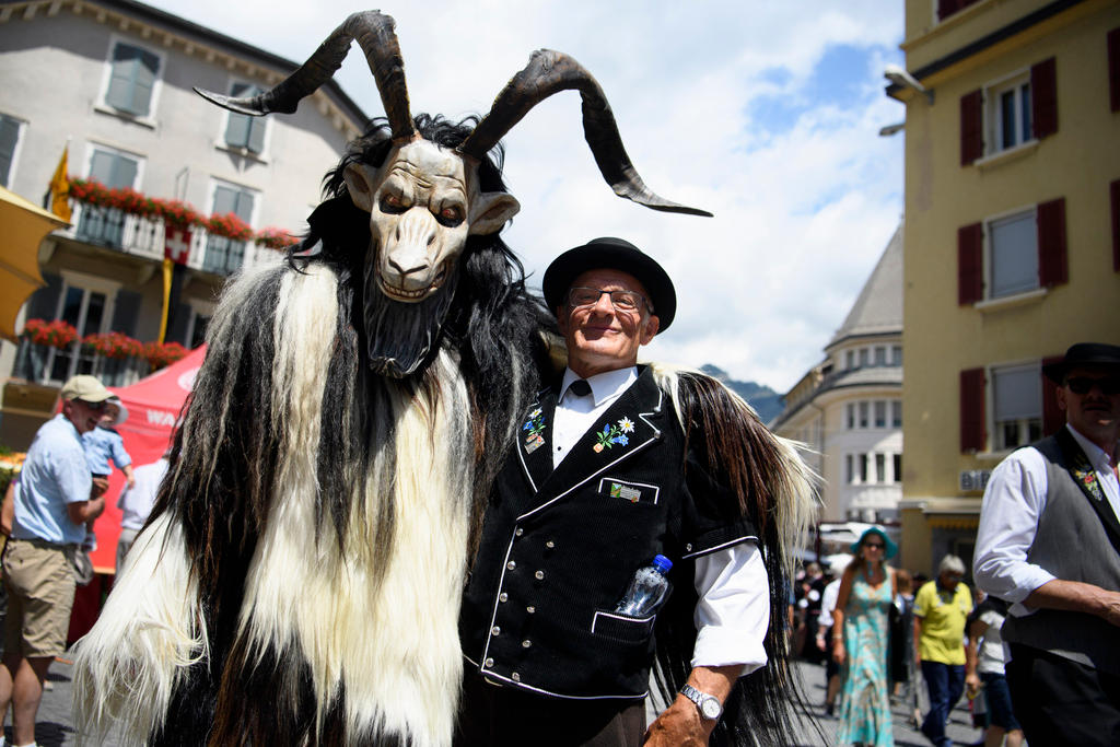 two men dressed in traditional costume, one as an animal with horns and the other wearing a traditional jacket