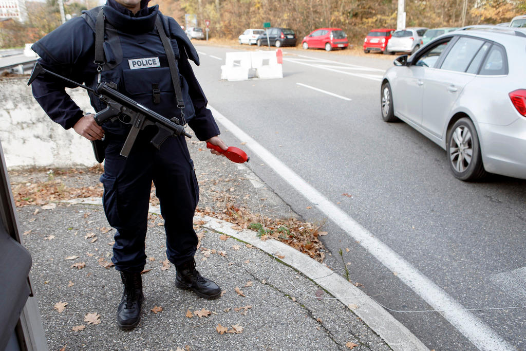 شرطي سويسري يحمل سلاحه في ضاحية مايرين بجنيف