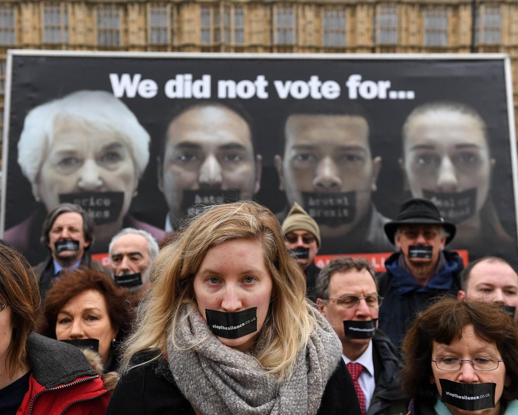 Protestors against Brexit vote in front of a poster outside parliament in London
