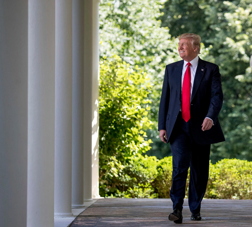 Il presidente americano Donald Trump mentre cammina sorridendo.