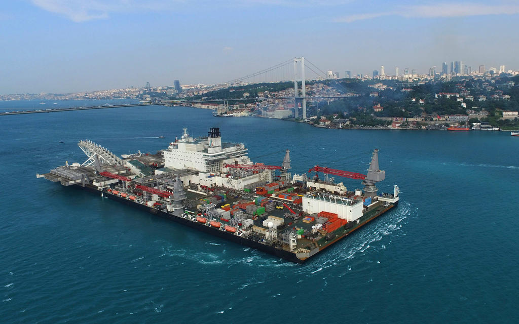 a very large construction vessel in water near to a harbour