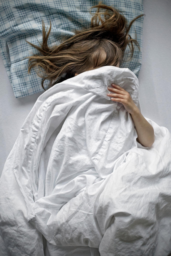 a girl hides under her bedsheets