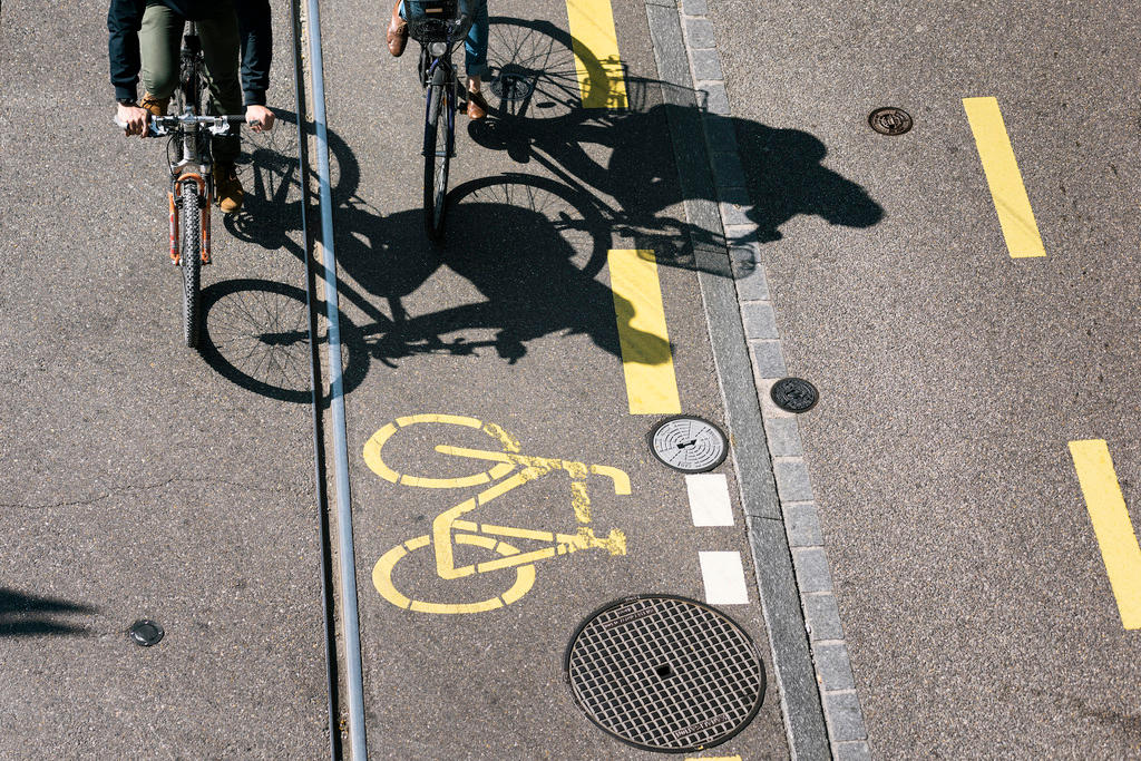 Two cyclists cycle on a cycle lane in Zurich, Switzerland, on April 8, 2017.