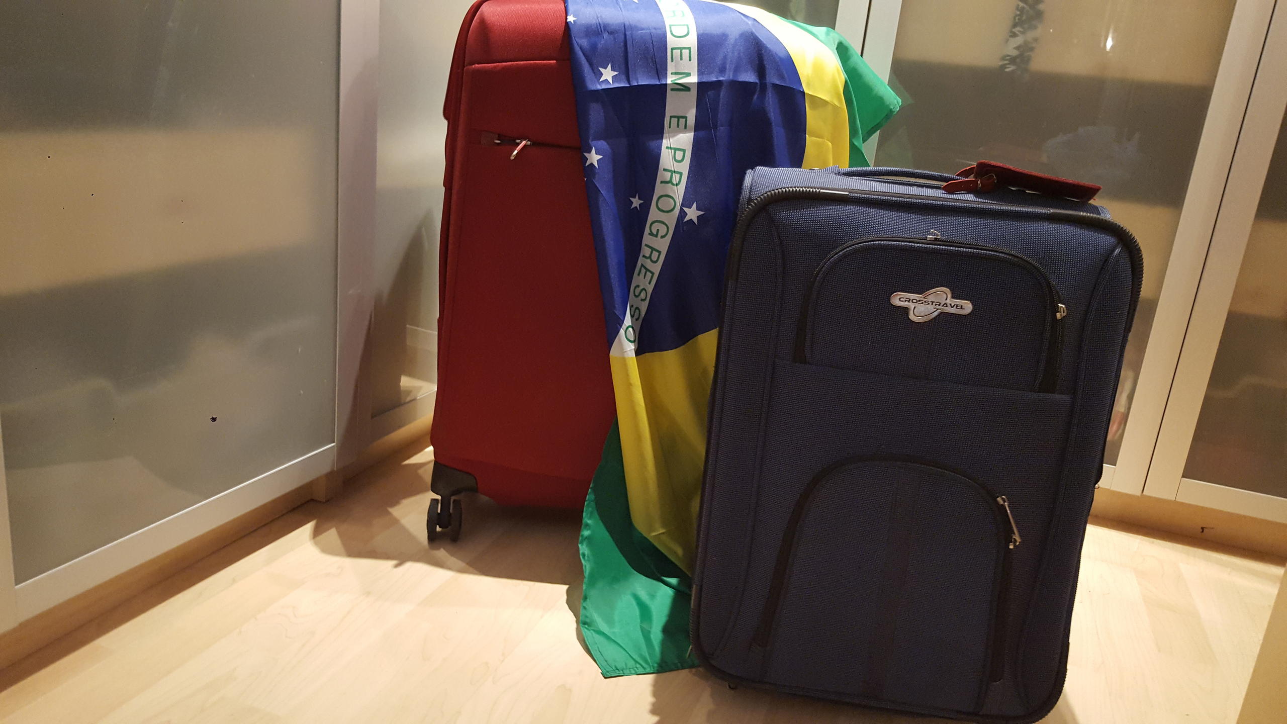 Duas malas e uma bandeira do Brasil