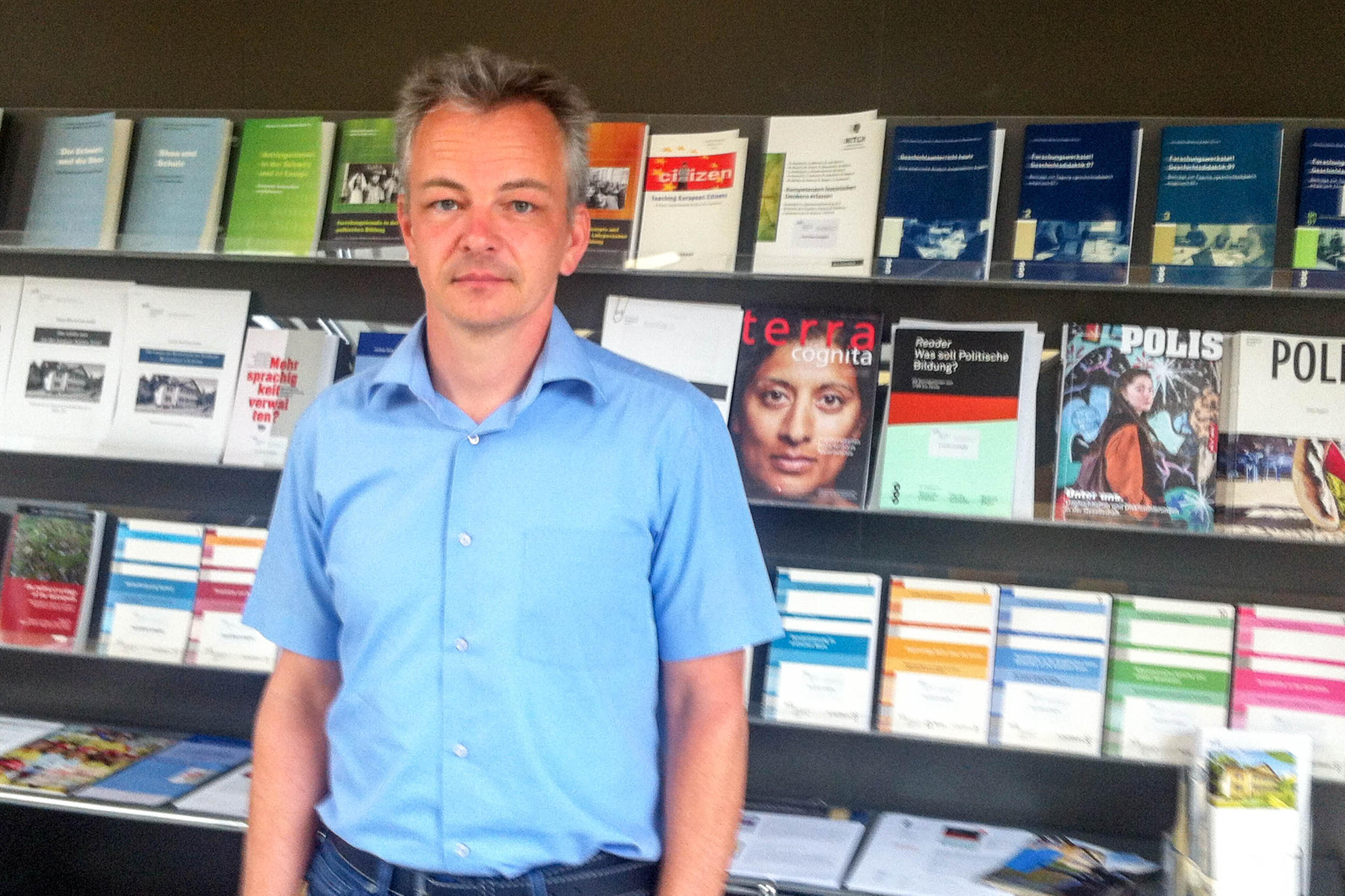 Daniel Kübler standing in front of a newspaper rack