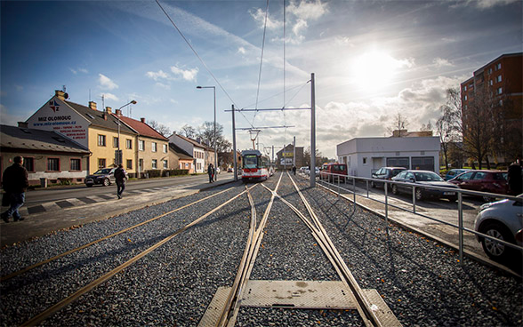 Bild von Tramschienen, die durch ein Städtchen führen.