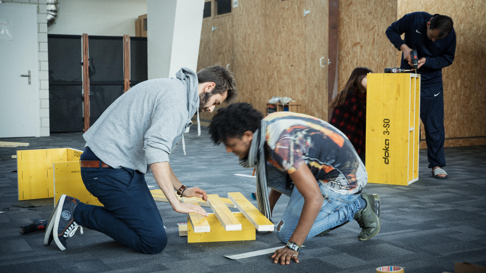 Swiss student helping asylum seeker build wooden bench