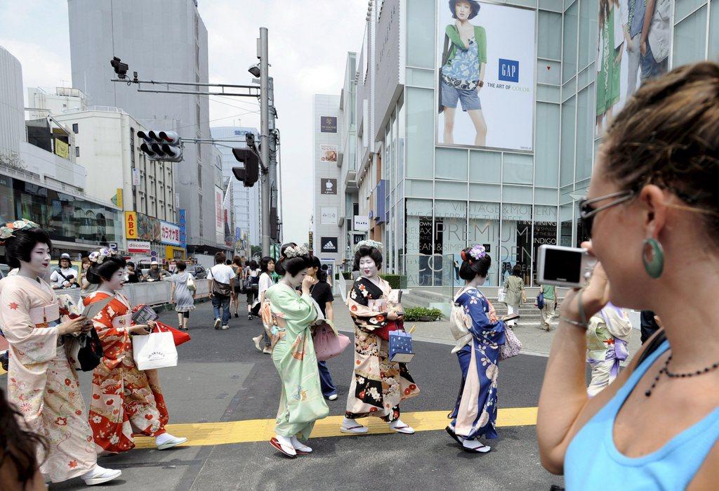 原宿を歩く芸者を撮影する外国人観光客