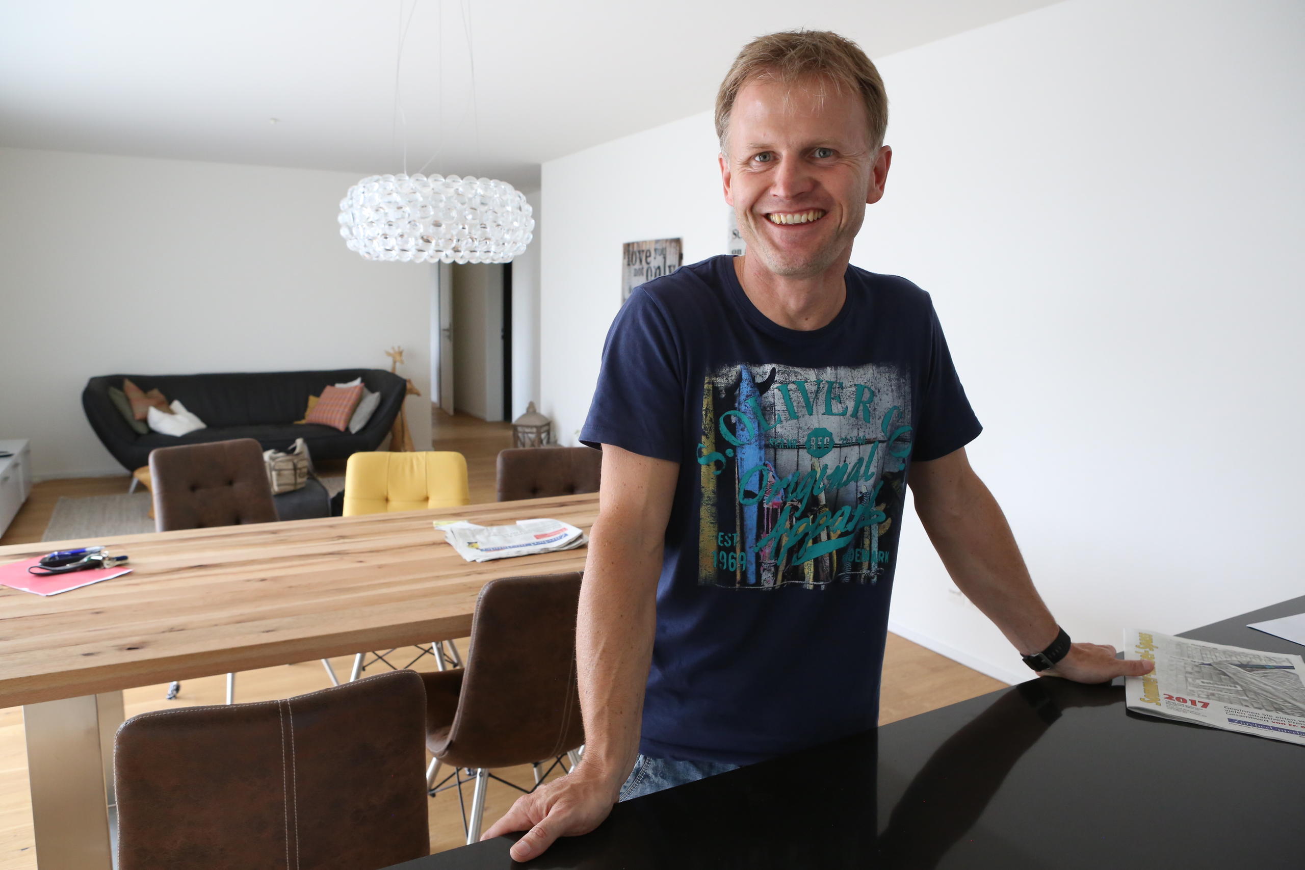Daniel Marty è appoggiato al bancone della cucina di casa sua