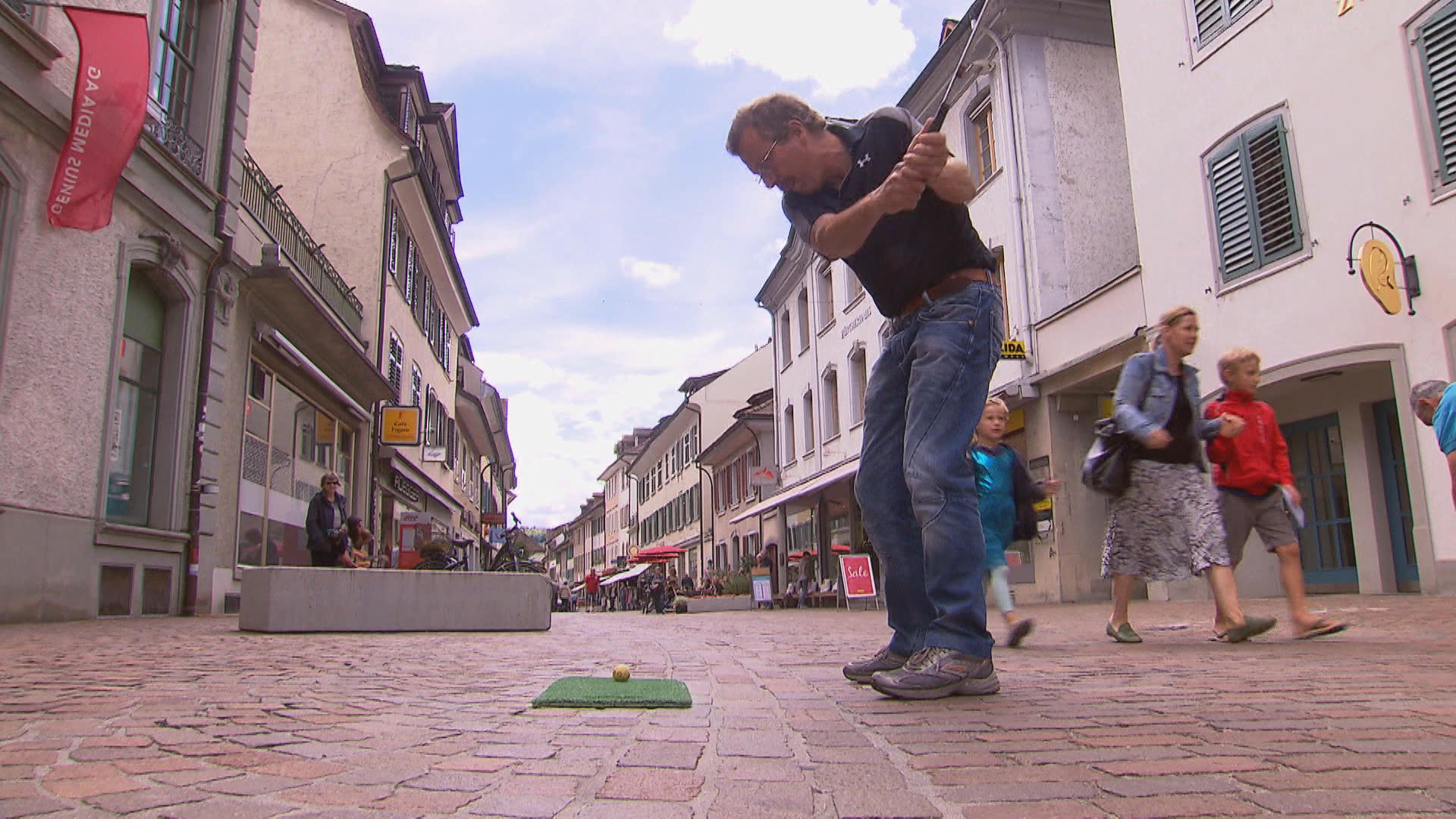 Man playing golf in shopping street