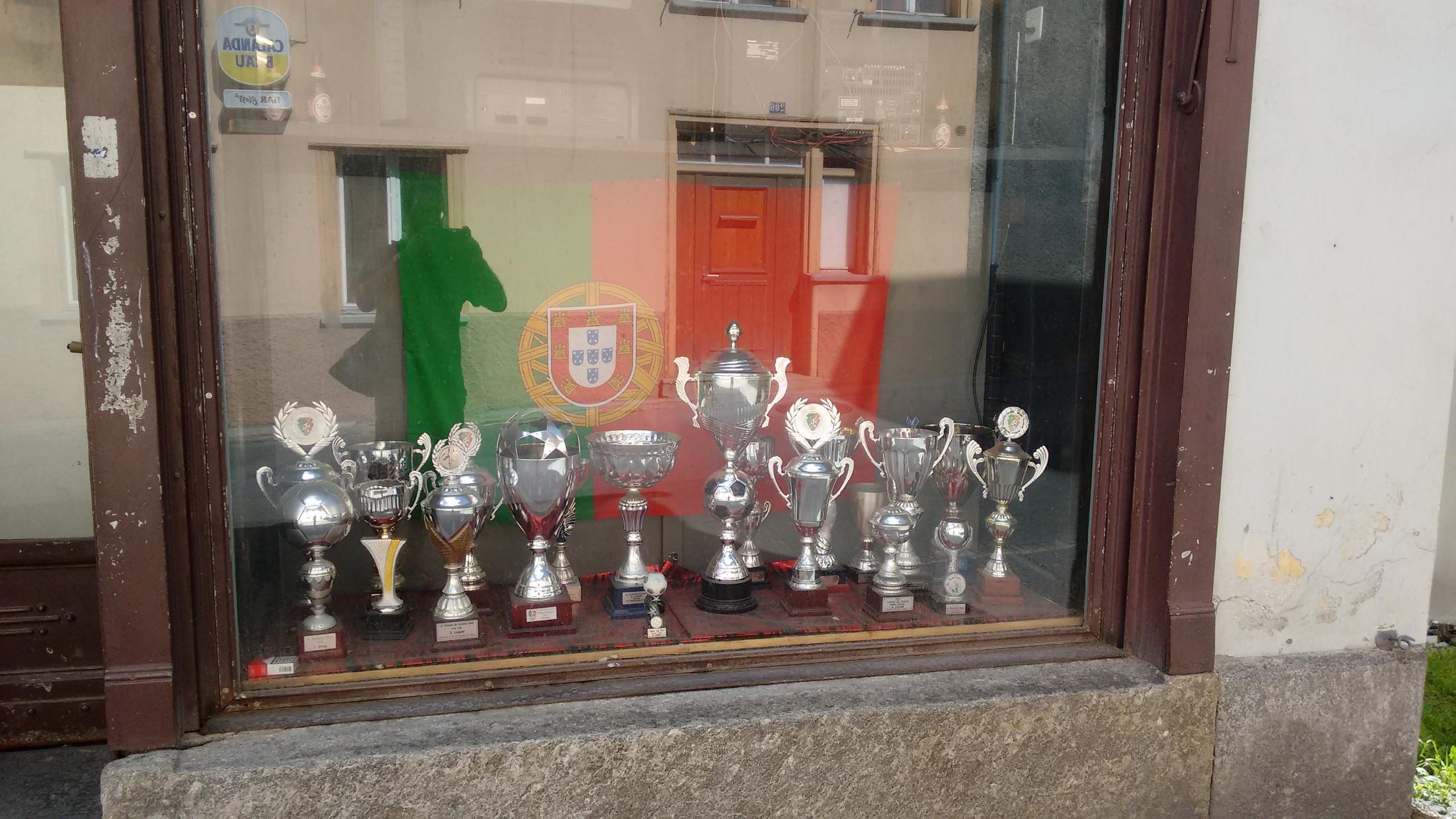 A bandeira portuguesa com troféus na vitrine de um pequeno clube português em Scuol, cantão dos Grisões