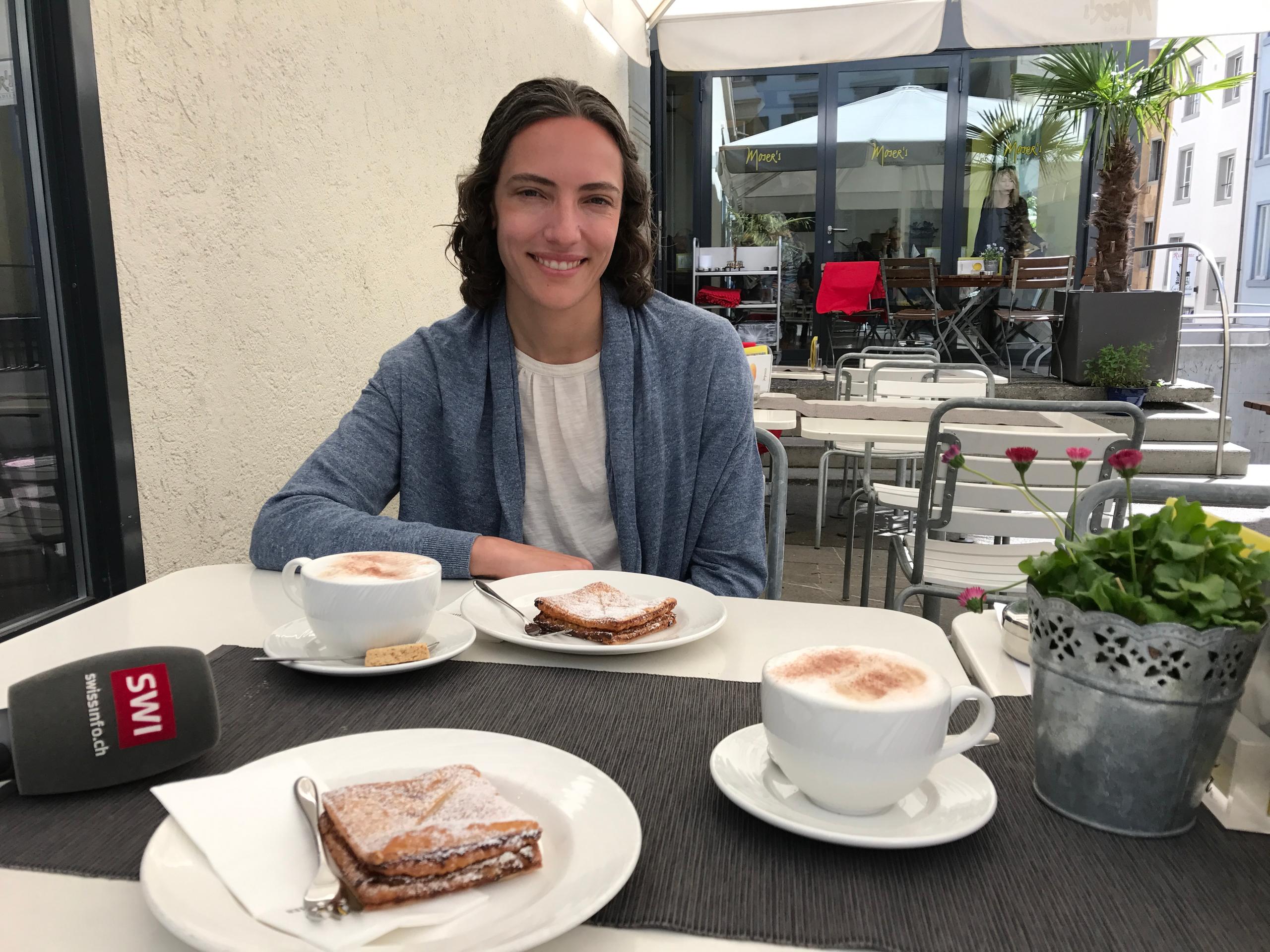Woman sitting at a cafe with coffee and pastry