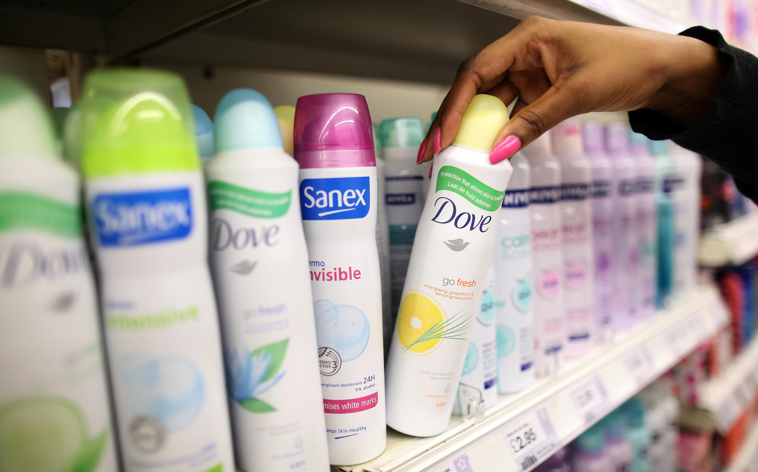 Cans of Dove deodorant sit with cans of Sanex deodorant at a supermarket in London, U.K., on Nov. 17, 2010