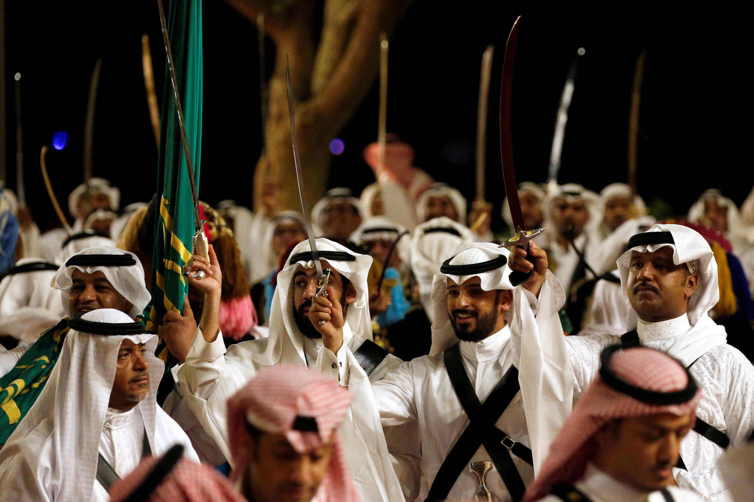 Men holding aloft swords during a welcoming ceremony for US President Trump in Riyadh