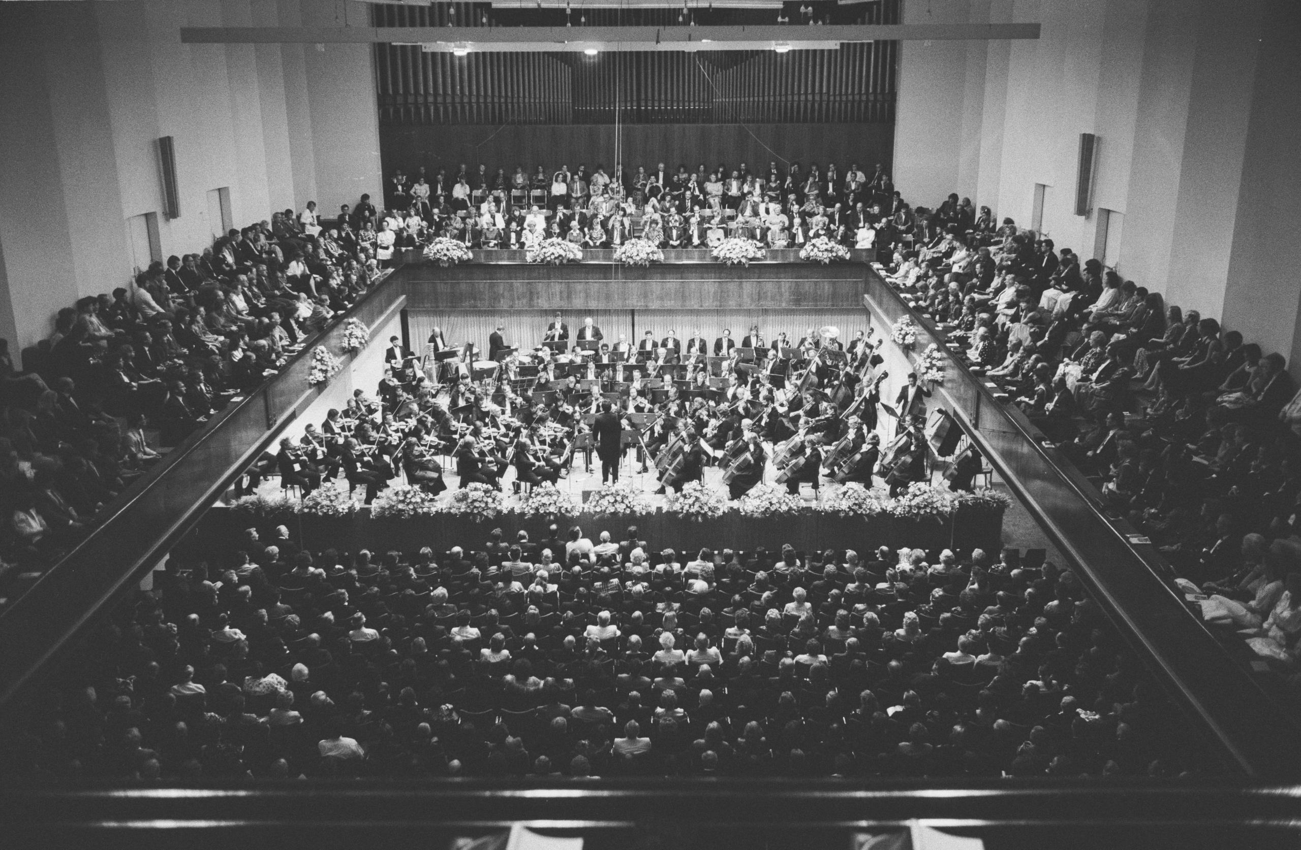 Ein Orchester spielt in einem Konzertsaal.