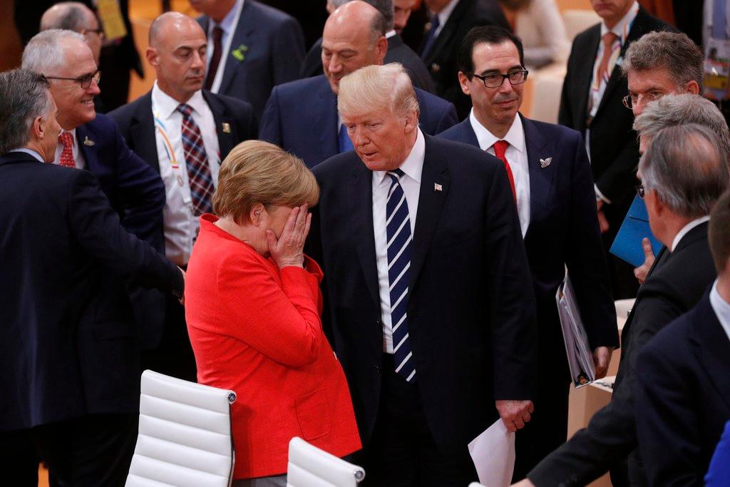 German Chancellor Angela Merkel buries her head in her hands next to US President Donald Trump