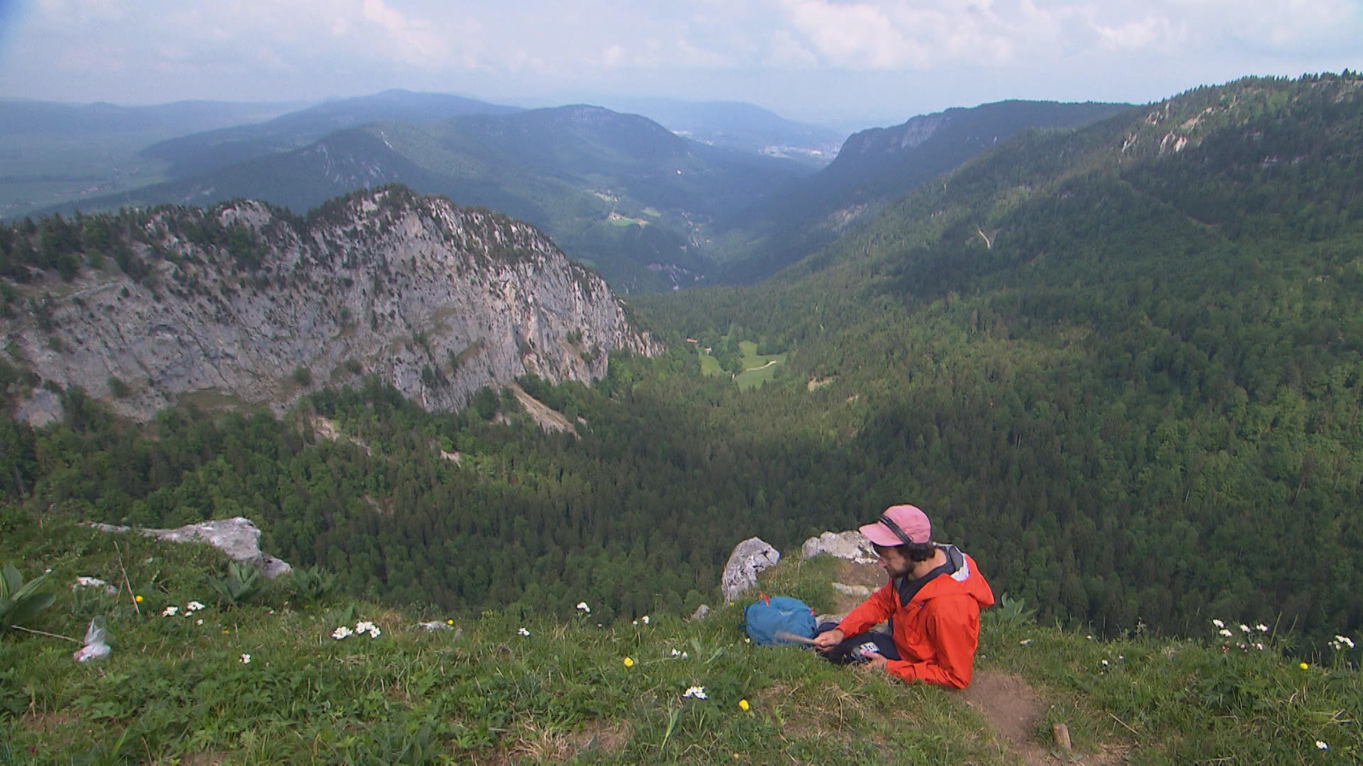 Young man drums on a stone before alpine ladscape