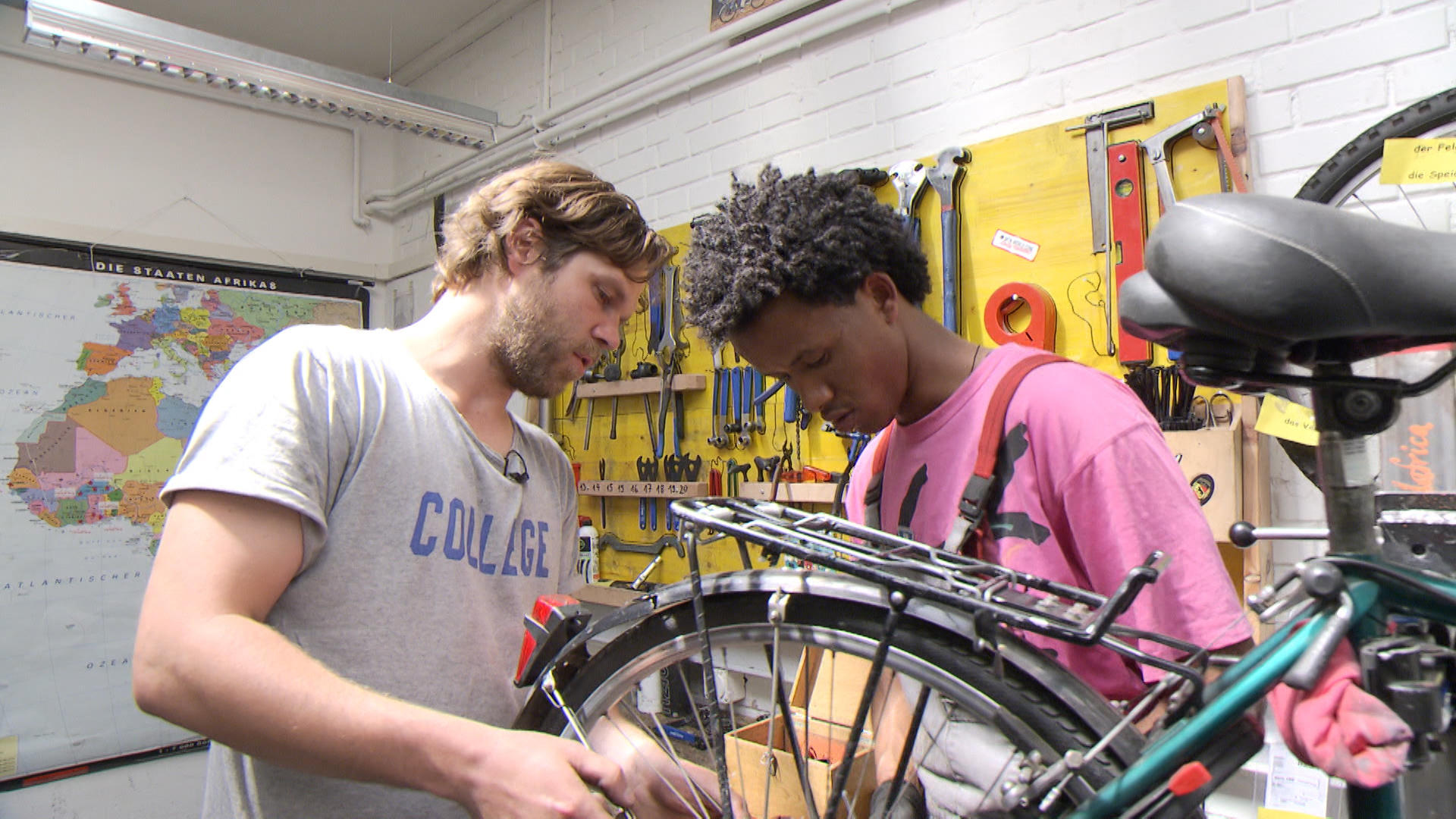 Two men repairing a bike