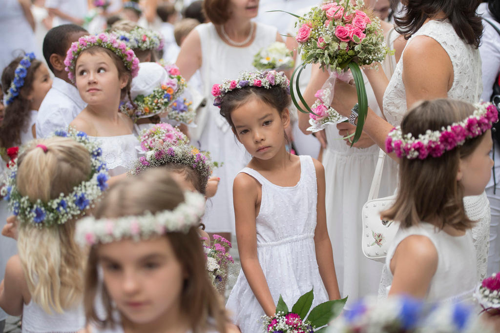 أطفال يرتدون ملابس بيضاء ويضعون أكاليل من الزهور فوق رؤوسهم احتفالا بعيد شعبي عريق في مدينة آراو السويسرية.