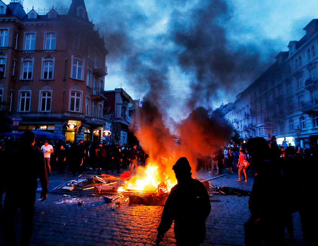 Protesters stay between fires on a street in Hamburg