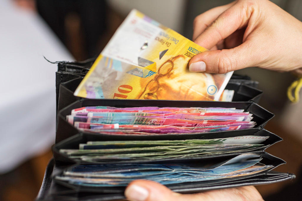 Mão tirando nota da carteira