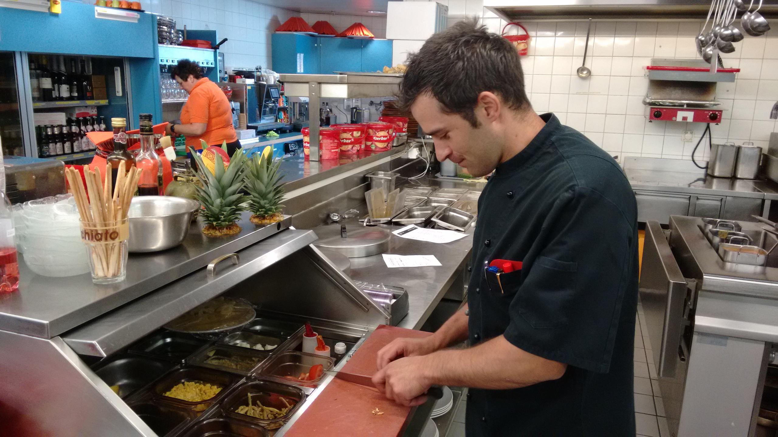 José cortando legumes no restaurante.