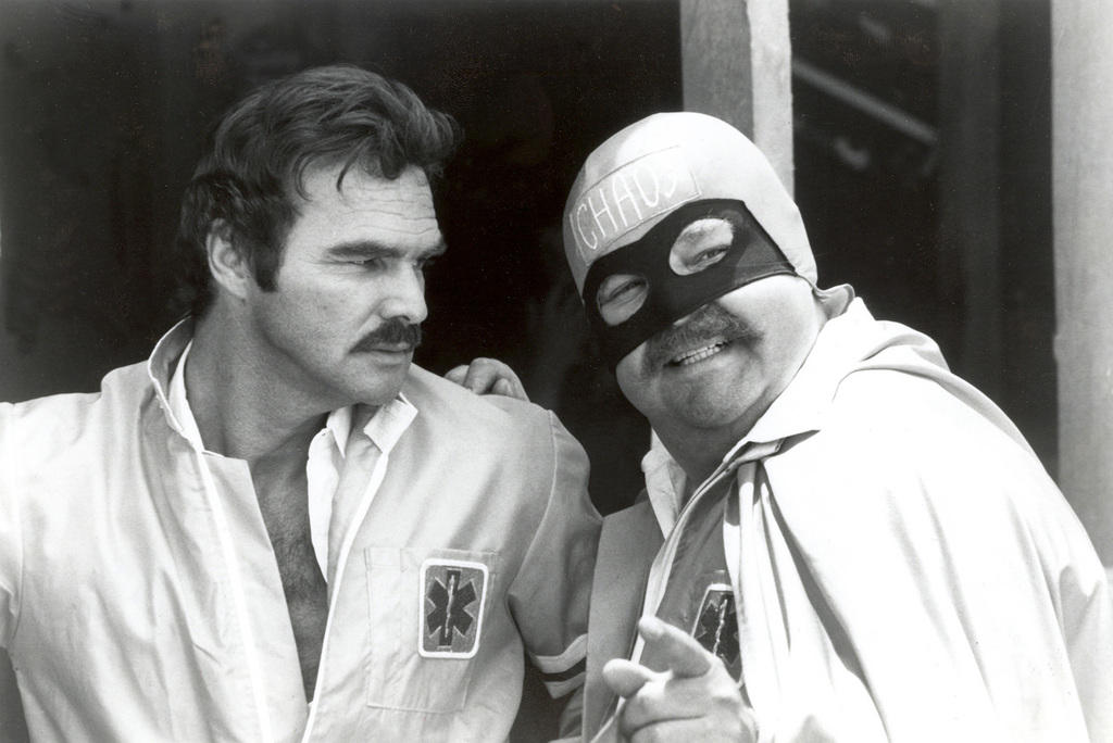 Burt Reynolds and Dom DeLuise, dressed in a cape and mask, on the set of the Cannonball Run movie