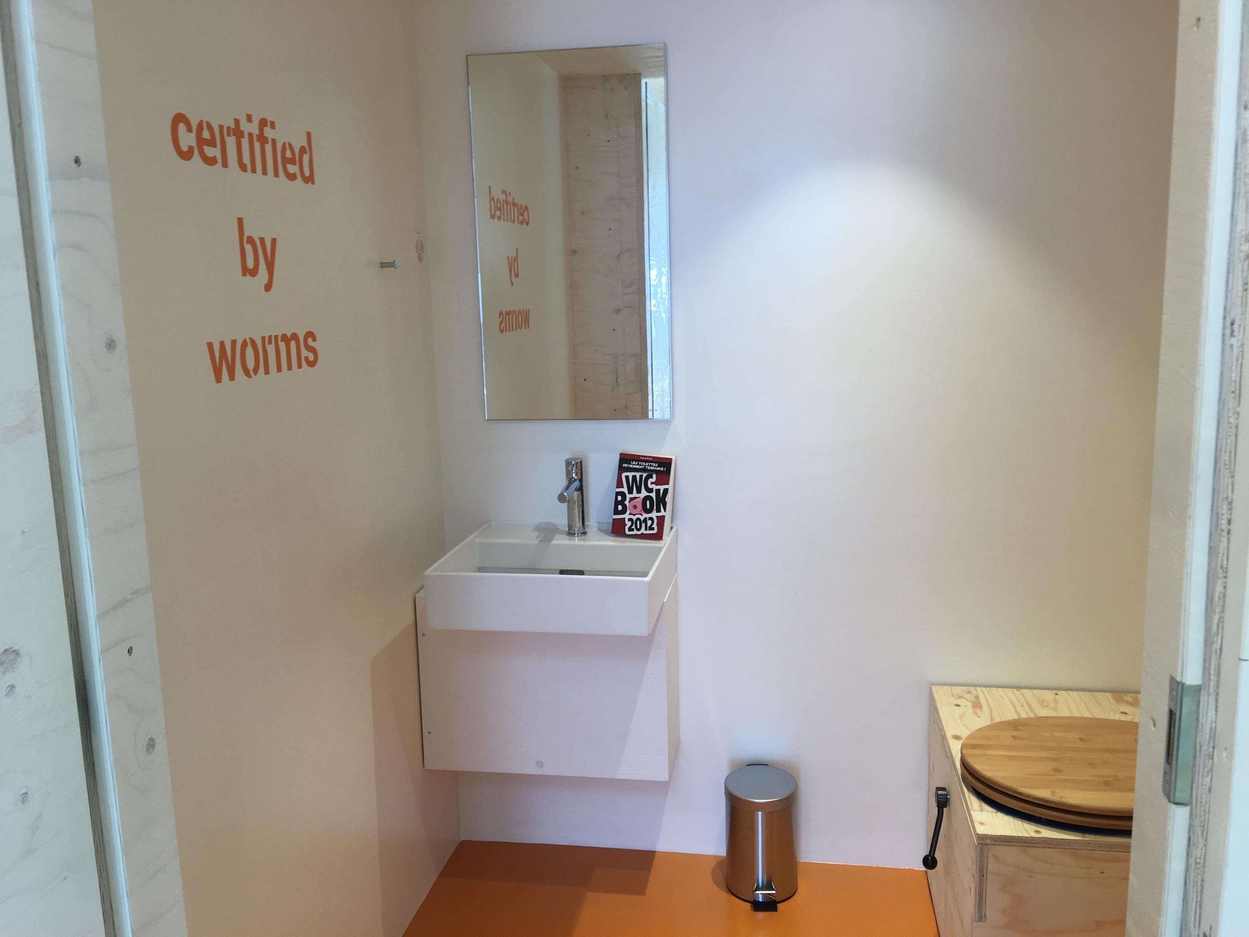 A sign in the bathroom says certified by worms